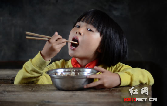 9岁的蒲晴绿,烂泥村小二年级正在吃免费午餐。