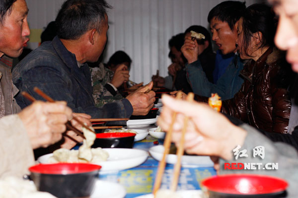 建筑工人们正在吃热气腾腾的饺子