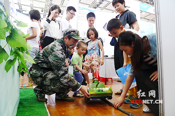 “挑战杯”终审竞赛作品现场展示。湖南生物机电职业技术学院的展位前，酷似坦克的机器人吸引了小朋友的围观。)